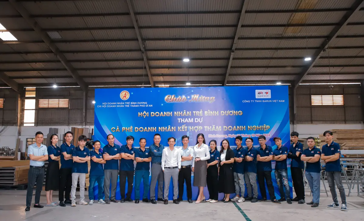 Đội ngũ nhân viên Barun Việt Nam chụp ảnh tập thể trong nhà máy trước backdrop chào mừng Hội Doanh nhân trẻ Bình Dương