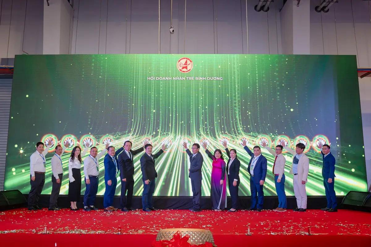 Các đại biểu thực hiện nghi thức khai mạc trên sân khấu Hội Doanh nhân trẻ Bình Dương, màn hình LED xanh lá phía sau